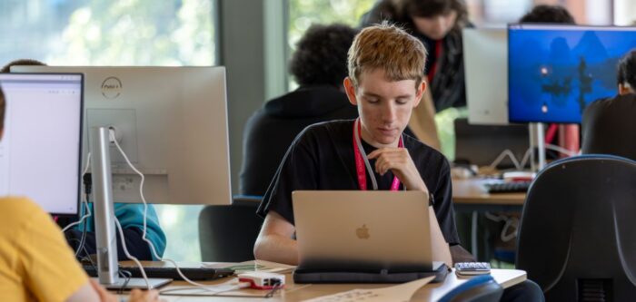 Student sitting at a table with a laptop