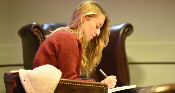 Student writing in coffee shop
