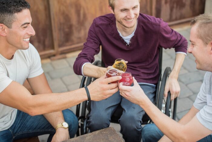 Three people socialising; one using a wheelchair