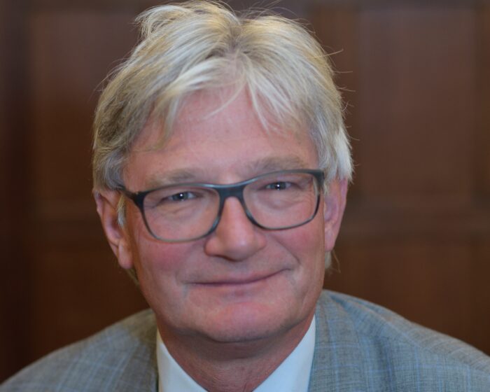 Portrait photograph of a man in glasses. He is Tim Harvey-Samuels, Bursar at Trinity Hall in Cambridge.