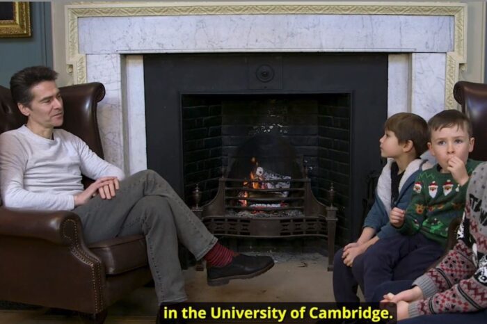 Marcus Tomalin on the left asks three boys on the right questions about Cambridge