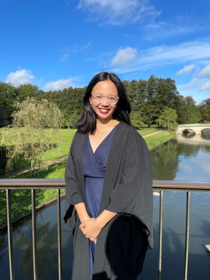 Young student Charlotte Wan standing on a bridge over the River Cam on a sunny day