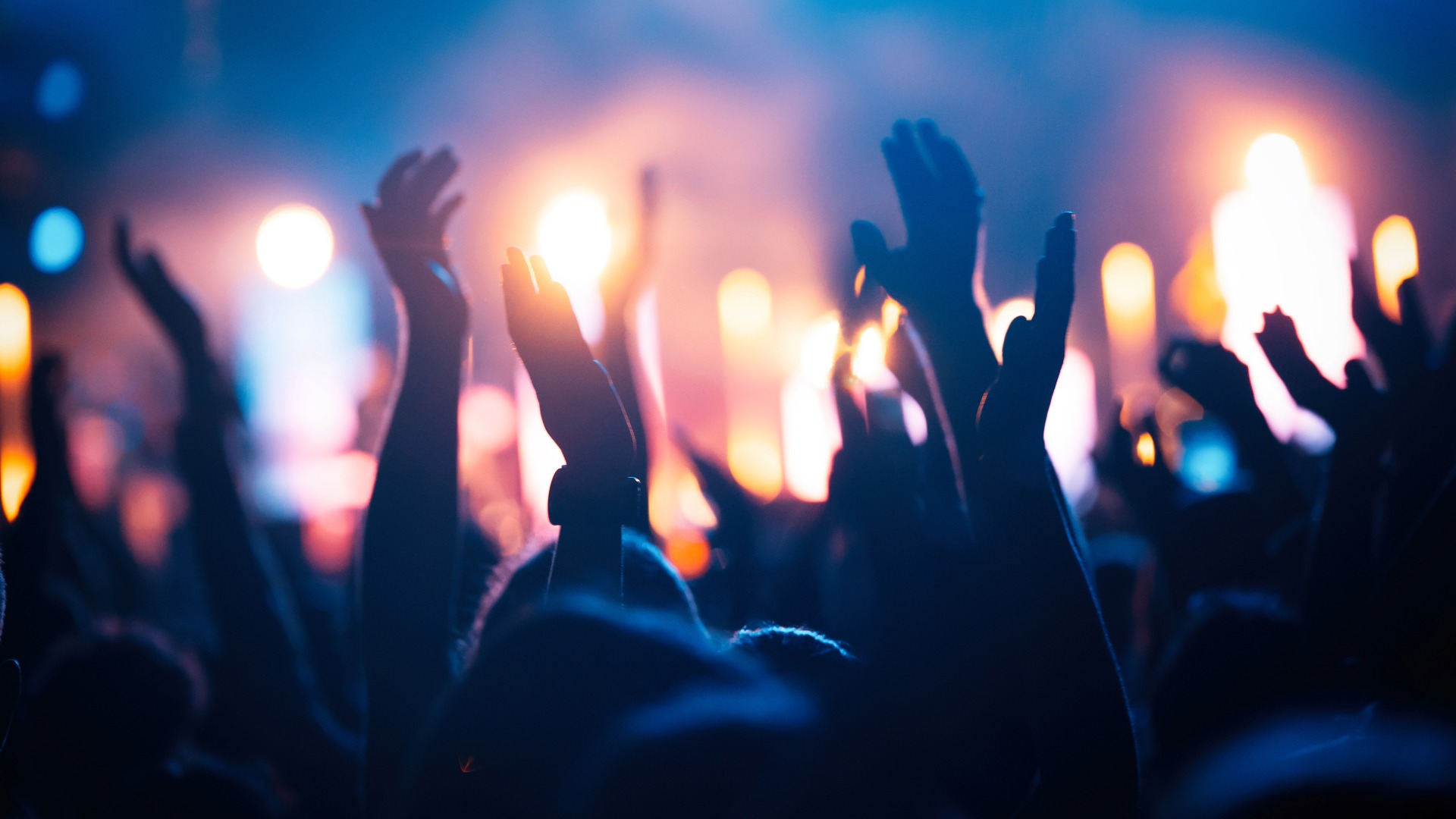 Stock image of crowd clapping at a concert.
