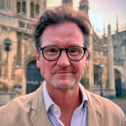 Colour photograph of a man smiling at the camera.