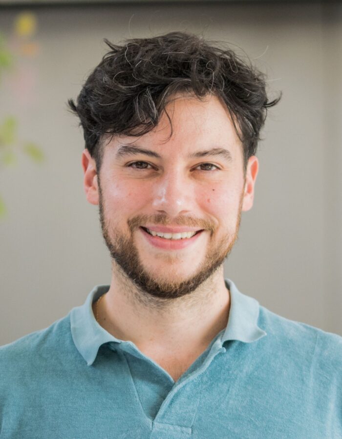 Colour photo of a man smiling at the camera.