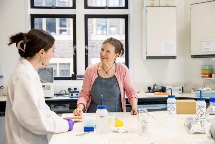 Dr Tamsin O'Connell and a postgraduate student talking in a brightly lit lab.