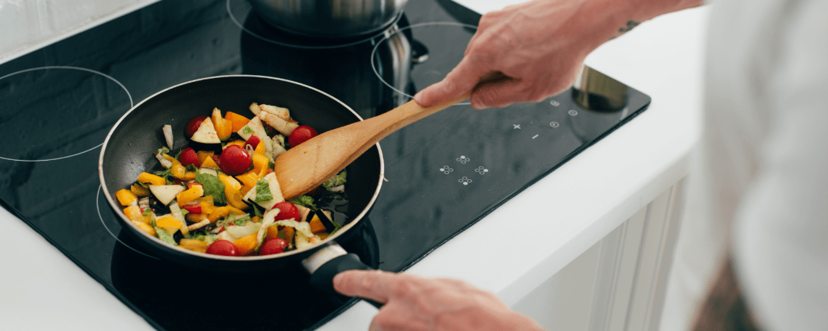 A person frying vegetables in a pan.
