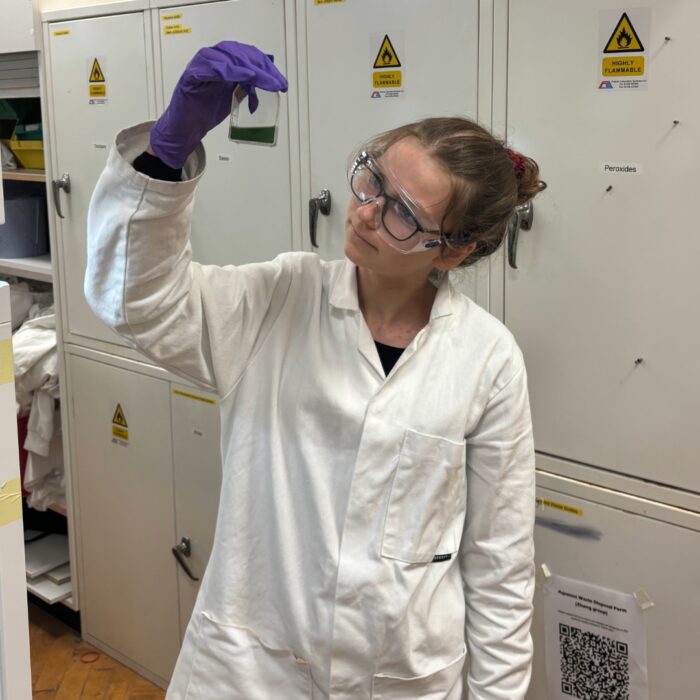 Elizabeth holding up a beaker of solution.