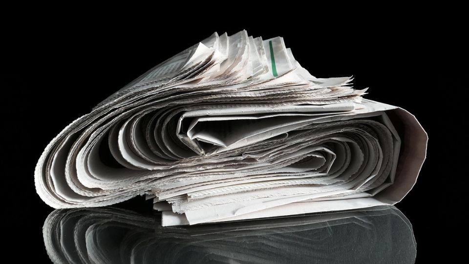 Roll of newspapers against a black background