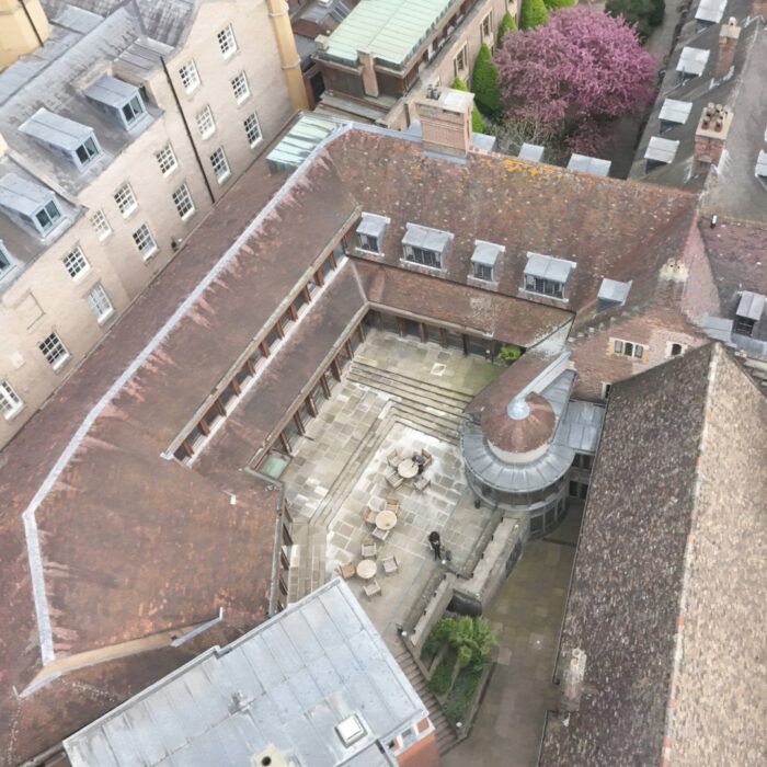 An aerial shot of a old courtyard, with table and chairs in the centre.