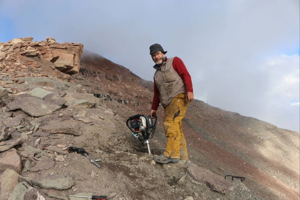 Professor John Marshall standing on a large rock formation.