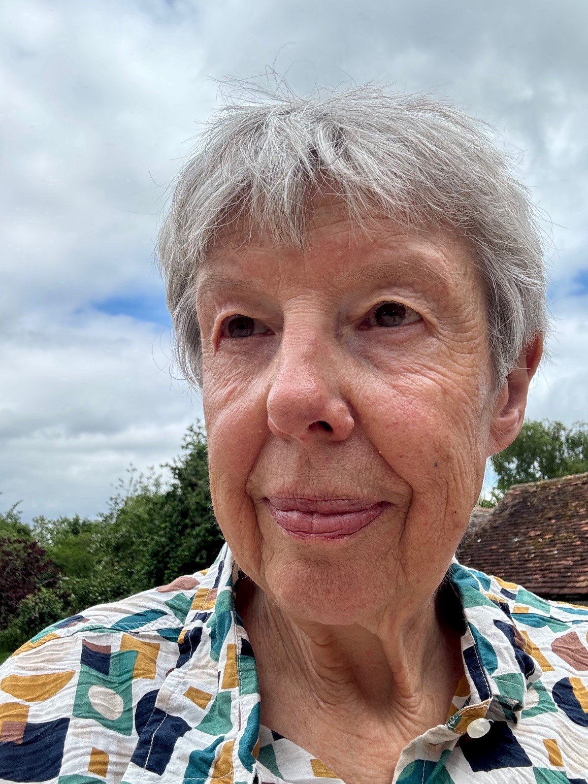 A close up of a woman in a green and yellow patterned shirt.