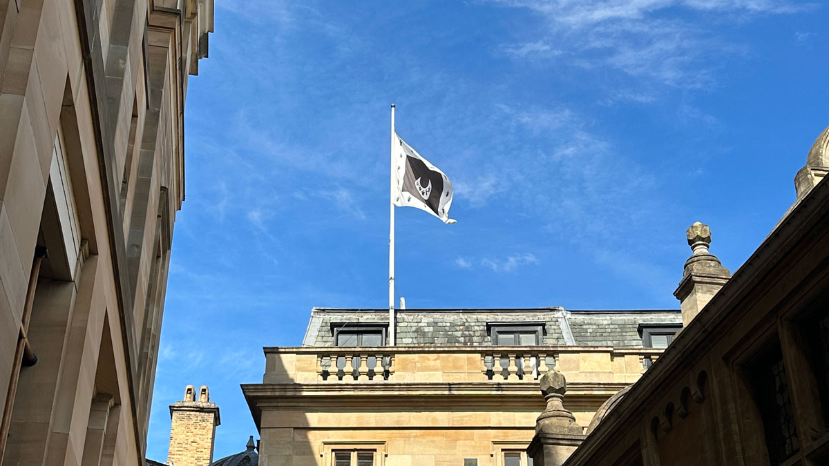 Trinity Hall flag flying half mast in a bright blue sky