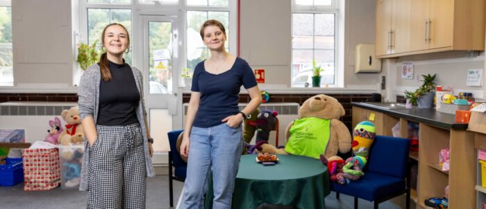 Two people stand smiling in a room. On the left is Kate Weir from Cambridge Acorn Project and on the right is Trinity Hall student Rosalind Howell